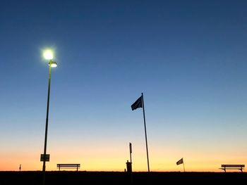 Low angle view of street lights against clear sky at sunset