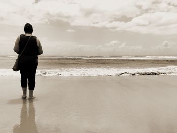 Rear view of man standing on beach