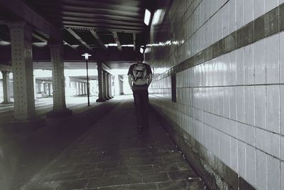 Rear view of man walking on underground walkway