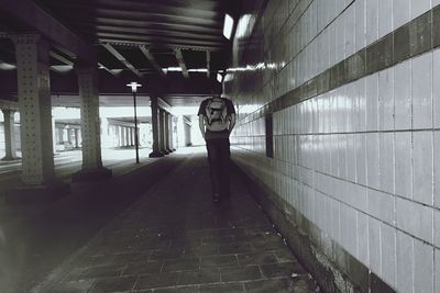 Man standing on illuminated corridor