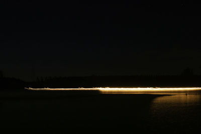 Scenic view of lake against clear sky at night