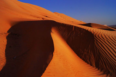 Sunlight falling on desert against blue sky