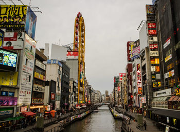 Canal amidst buildings in city against sky