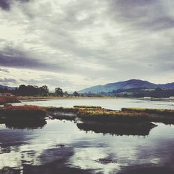 Scenic view of lake against cloudy sky