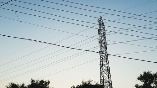 Low angle view of electricity pylon against clear sky