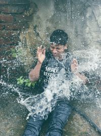 Man splashing water in swimming pool