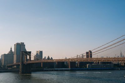 Bridge over calm river with buildings in background