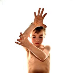 Shirtless boy gesturing against white background