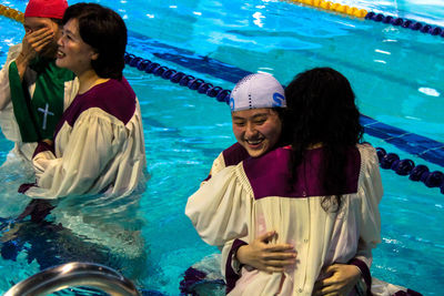 Full length of a smiling young woman in swimming pool