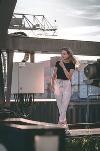 Portrait of woman standing against railing