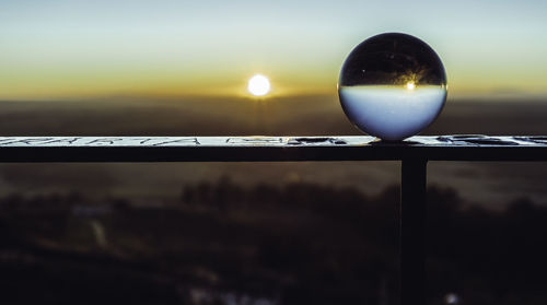 Close-up of silhouette sun against sky during sunset