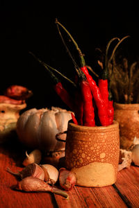 Close-up of red chili peppers on table against black background