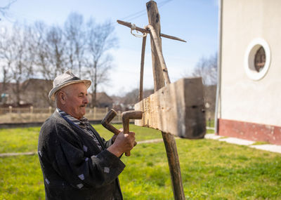 Man holding umbrella standing on field