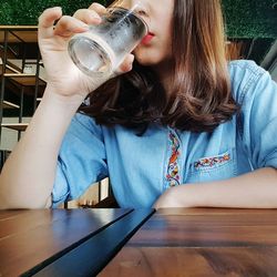 Midsection of woman drinking water at restaurant