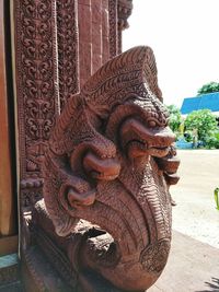 Close-up of buddha statue against building