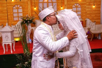 Portrait of a couple with a blissful kiss pose at the time of the wedding celebration