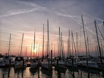 Silhouette harbor against sky at sunset