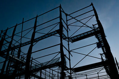 Low angle view of silhouette metallic structure against sky