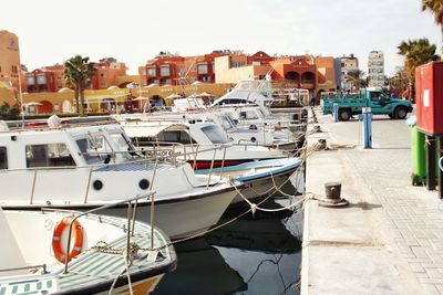 Boats moored at harbor against sky