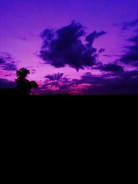 Silhouette landscape against dramatic sky during sunset