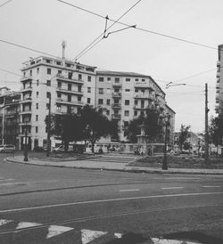 Railroad tracks by buildings in city against sky