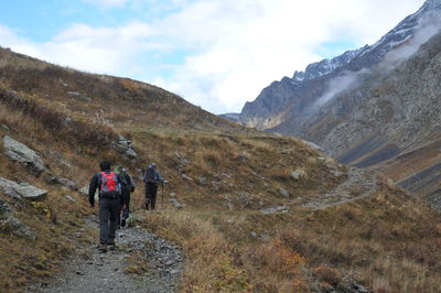 Rear view of men walking on mountain trail