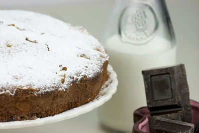 Close-up of cake with milk and chocolate bars on table