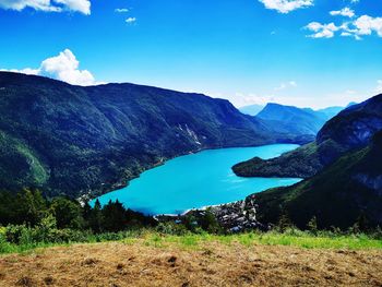 Scenic view of lake and mountains against blue sky