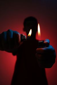 Close-up of hand holding lit candle