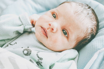 Portrait of baby girl lying on bed