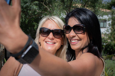 Smiling woman taking selfie with friend