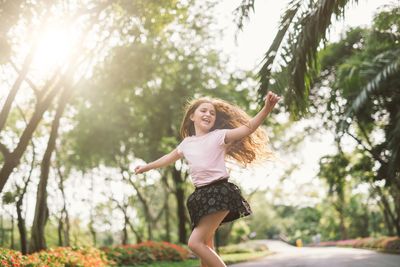 Young woman smiling against trees