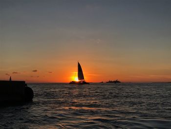 Sailboat sailing on sea against sky during sunset