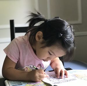 Portrait of a girl writing on table