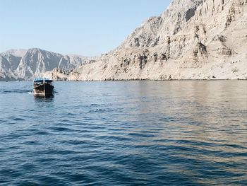 Scenic view of sea and mountains against clear sky