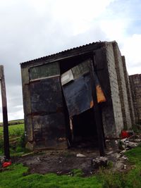 Built structure on field against cloudy sky