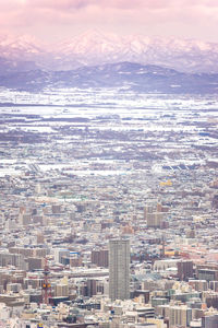 Aerial view of cityscape by sea against sky