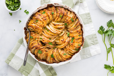 Gourmet scalloped potatoes garnished with fresh parsley, ready for serving.