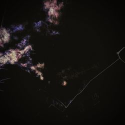 Low angle view of illuminated fireworks against sky at night
