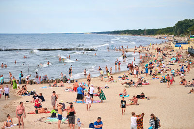 Public sandy beach with vacationers tourists. tourist season on baltic sea coast. people on beach