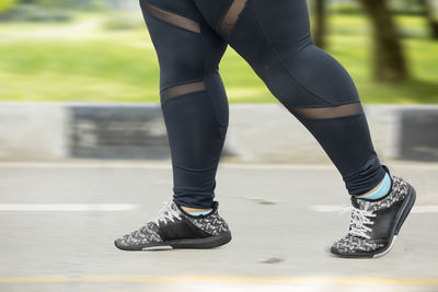 Low section of woman running on road