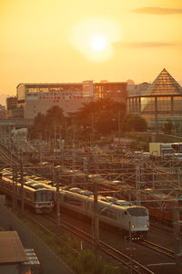 Train on railroad tracks against sky during sunset