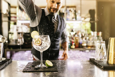 Bartender making drink at bar