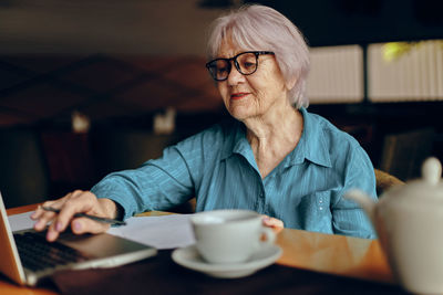 Businesswoman working on laptop at cafe