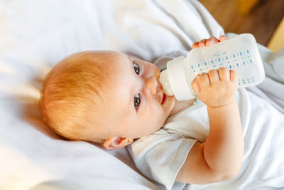 Close-up of cute baby boy sleeping on bed