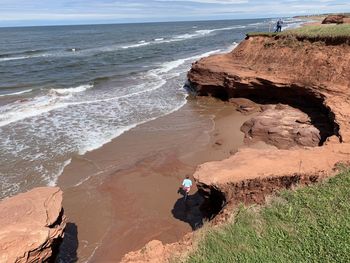 Man sitting on rock at beach