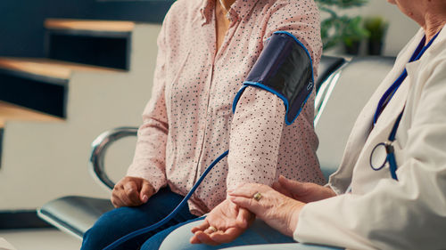 Midsection of doctor examining patient in clinic