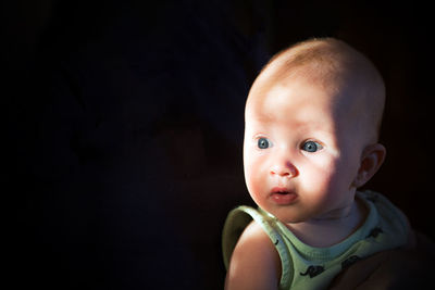 Cute girl looking away against black background