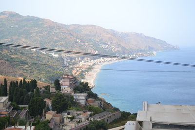 Aerial view of city by sea against clear sky