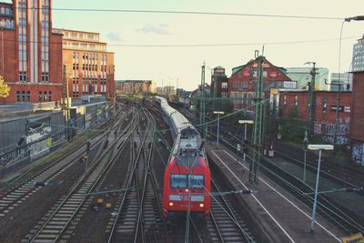 Train on railroad tracks in city against sky